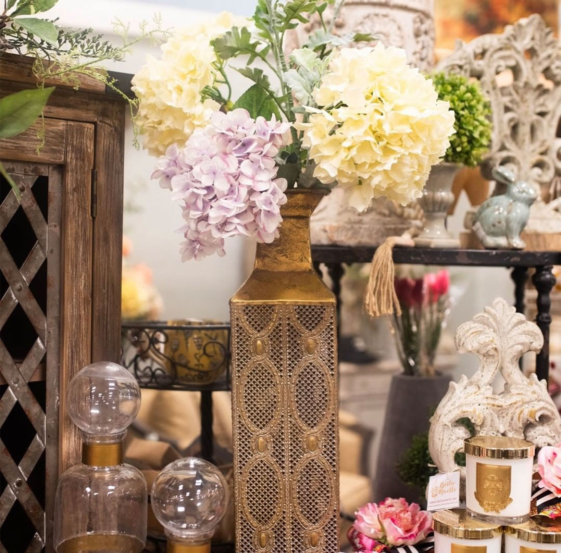 a bronze vase with flowers and various home decor gifts