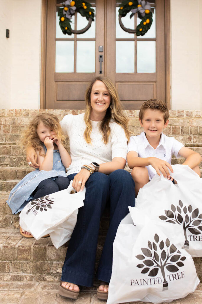 smiling family holding Painted Tree shopping bags