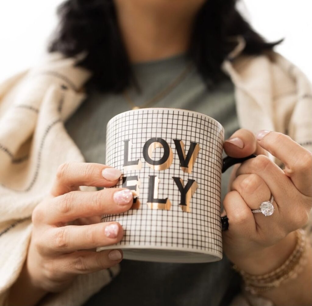 woman holding a mug with the word "lovely" on it