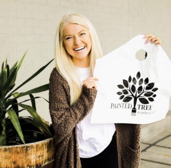 smiling woman holding Painted Tree bag